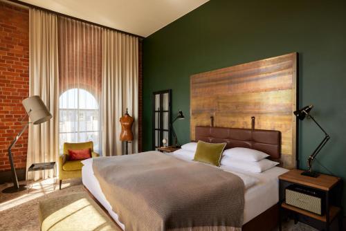 a bedroom with a large bed and a green wall at Gastwerk Hotel Hamburg in Hamburg