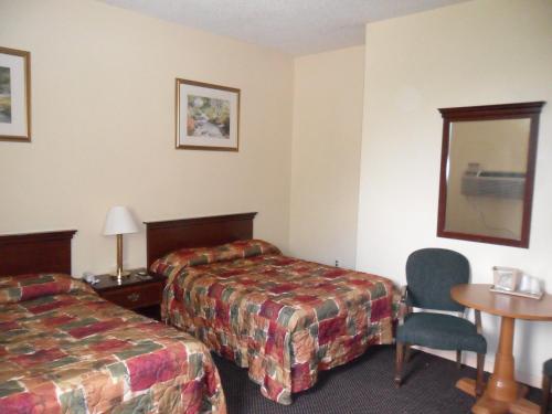 a hotel room with two beds and a table at Red Carpet Inn Brooklawn in Brooklawn