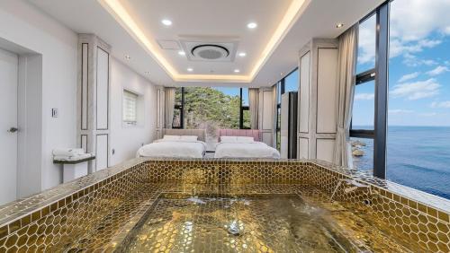 a bathroom with a tub with a view of the ocean at yongdeok marryel poolvilla in Yŏngdŏk
