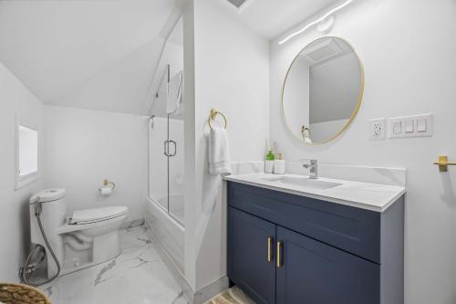 a bathroom with a sink and a toilet and a mirror at Lake Drive apartment in Georgina