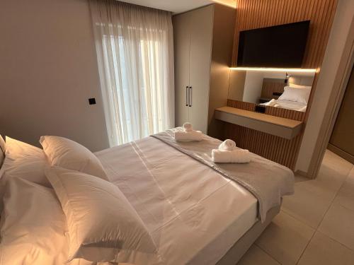 a bedroom with a large white bed with towels on it at Latsis Suites in Moláoi