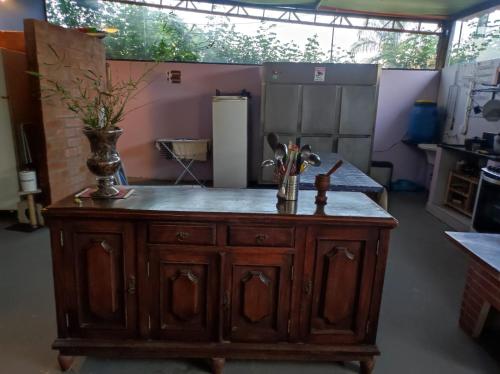 a kitchen with a counter with flowers on it at Hostel Oasis Jaguariuna in Jaguariúna