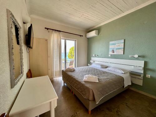 a bedroom with a bed and a table and a window at Galini Studios and Apartments in Lassi