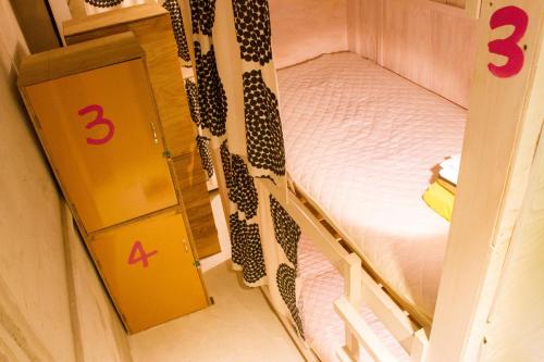 een kleine slaapkamer met een stapelbed en 2 bedden bij Hostel Nakamura Kobe in Kobe