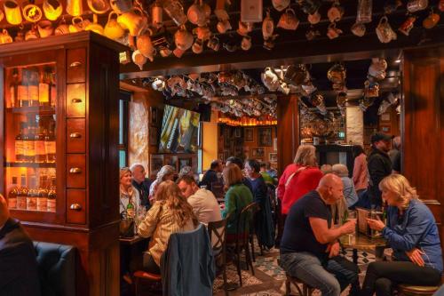 a group of people sitting at tables in a bar at Nesbitt Arms Boutique Hotel in Ardara