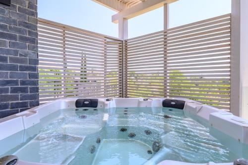 a hot tub in a room with a large window at ציפור הכנרת - סוויטה מבודדת נוף לכנרת in Had Nes