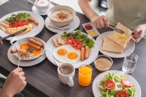 a table with plates of breakfast food on it at V Style Pattaya North Beach in Pattaya