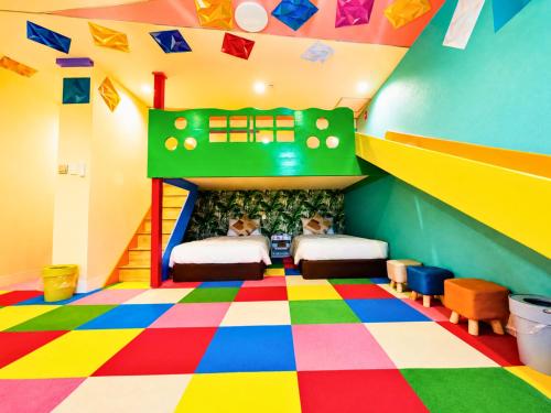 a room with two beds and a colorful floor at Rycom Family Resort Hotel in Okinawa City