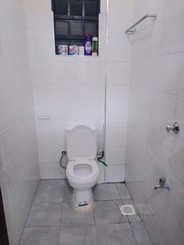 a white bathroom with a toilet and a shower at Maridadi place in Kakamega