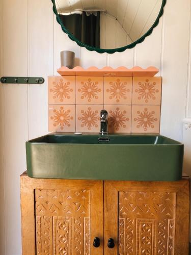 a bathroom with a green sink and a mirror at Gawra Bogusza in Lądek-Zdrój