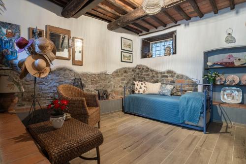 a bedroom with a bed and chairs in a room at La Casa del Grillo Parlante in Collodi