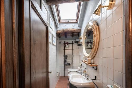 a bathroom with a sink and a mirror and a toilet at La Casa del Grillo Parlante in Collodi