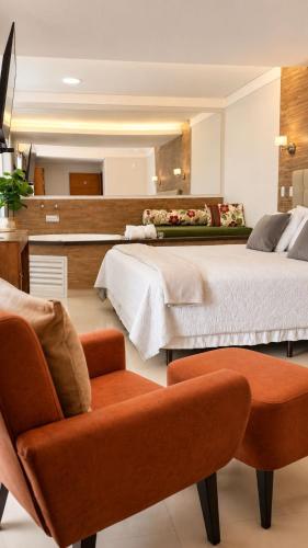 a bedroom with two beds and a chair in it at Hotel Terras da Finlândia in Penedo