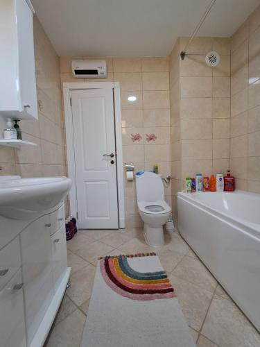 a bathroom with a toilet and a tub and a sink at Apartman PETRA QUEEN in Plužine
