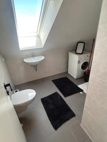 a bathroom with a sink and a toilet and a window at Monteur Zimmer Künzing in Künzing