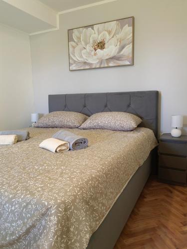 a bedroom with a bed with a flower picture on the wall at Apartman Aurora in Ičići
