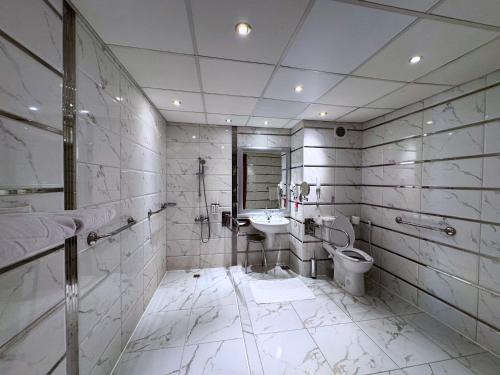 a white bathroom with a sink and a toilet at Sea Star Beau Rivage Hotel in Hurghada