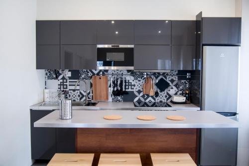 a kitchen with black cabinets and a white counter top at Apartamento com 2 Quartos e Vista oceano in Ovar