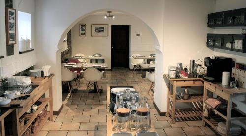 a kitchen with an archway and a table in a room at Eifel-Quartiere "Pension Müscher Bahnhof" in Müsch