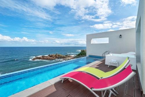 a room with a swimming pool with a view of the ocean at Youngdeok Bell Mar Poolvilla in Yŏngdŏk
