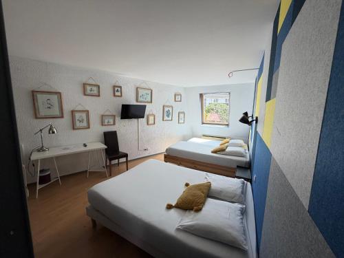 a room with three beds and a desk in it at Brit Hotel Dijon Centre Gare in Dijon