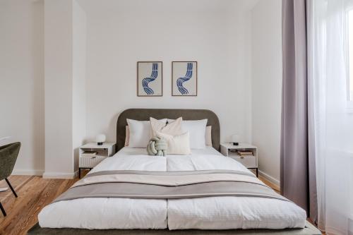 a bedroom with a large white bed with two night stands at Potsdam Classic Apartment in Potsdam