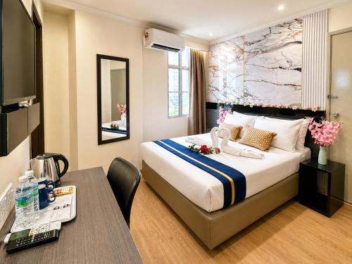 a hotel room with a bed and a desk at Central City Hotel at Chinatown in Kuala Lumpur