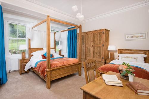 a bedroom with two beds and a desk and a table at Stucktaymore in Killin