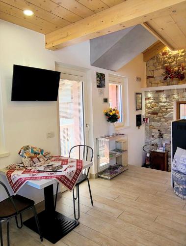 a living room with a table and a tv on the wall at Antico Borgo Fonzaso in Fonzaso