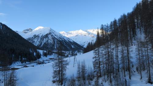 a snow covered mountain with trees and a ski lift at Garni Soldanella in Samnaun