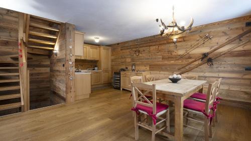 a kitchen with wooden walls and a table and chairs at Chalet Sozzine in Ponte di Legno
