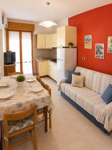 a living room with a table and a couch at Condominio Cristina - Agenzia Cocal in Caorle