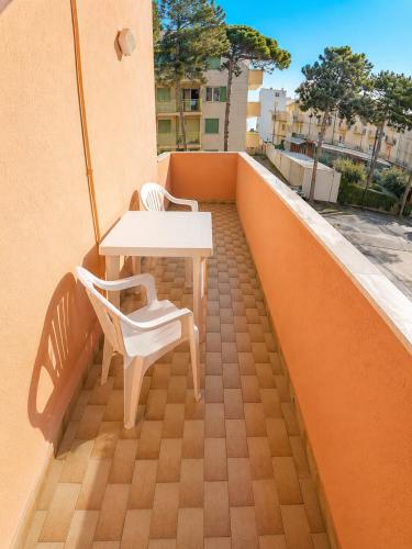 a table and a chair on a balcony at Condominio Cristina - Agenzia Cocal in Caorle