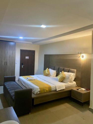 a bedroom with a large bed and a couch at Bridgewaters Hotel in Abuja