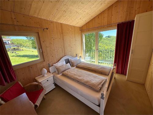 a bedroom with a bed in a room with a window at Panoramic views on Monte Generoso, peace & nature in Castel San Pietro