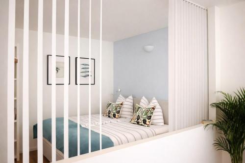 a room with a white crib with pillows at APSTAY central station I Self Check-in I Parking option in Graz