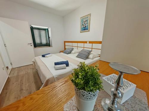 a bedroom with a bed and a plant on the floor at Villa Solaris in Donje Rašćane