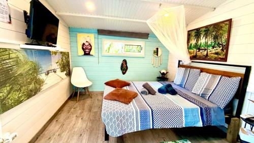a bedroom with a bed and a television in it at Bungalow La Perle - Jacuzzi - Piscine in Saint-François