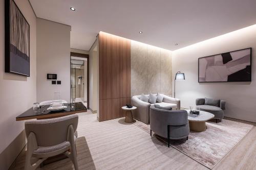 a living room with a couch and a table and chairs at Locanda Homes by Jareed لوكاندا هومز باي جريد in Riyadh