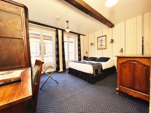 ein Schlafzimmer mit einem Bett und einer Kommode in der Unterkunft Hotel De La Poste in Langres