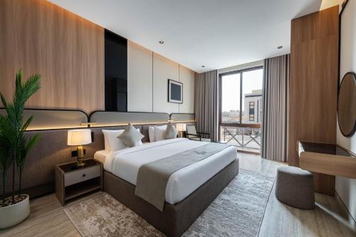 a hotel room with a large bed and a balcony at Locanda Homes by Jareed لوكاندا هومز باي جريد in Riyadh