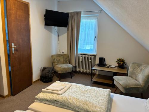 a bedroom with a bed and a chair and a window at Haus Sissi in Daun