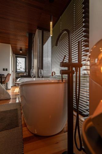 a bathroom with a large tub and a sink at Studio Sunrise - Luxo, Romance e Natureza in Rancho Queimado