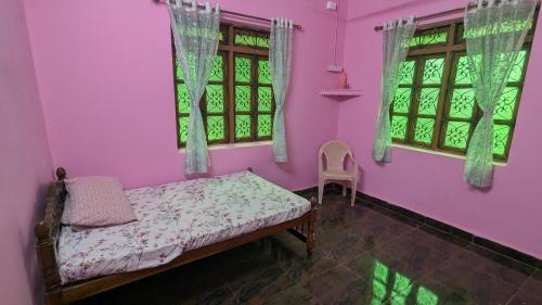 a bedroom with pink walls and a bed and windows at Villa Estrela Holiday Escape in Betalbatim