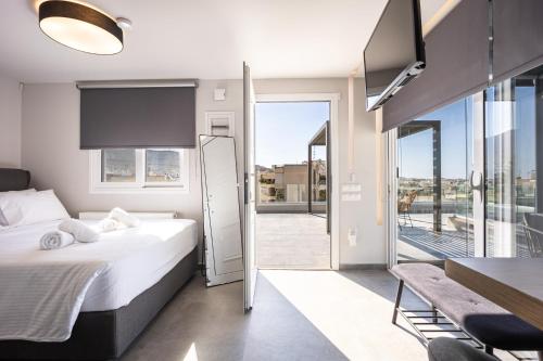 a bedroom with a bed and a view of a balcony at Glyfadas's Rooftop Blyss in Athens