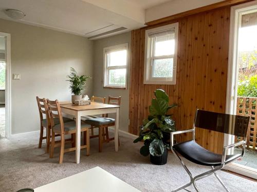 a dining room with a table and chairs and windows at 2-Bedroom Suite in North Vancouver