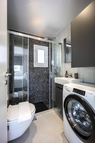 a bathroom with a washing machine and a shower at Glyfadas's Rooftop Blyss in Athens