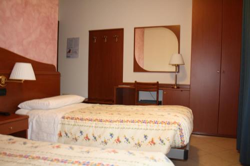 a hotel room with two beds and a mirror at Italia Risorta in Arsiero