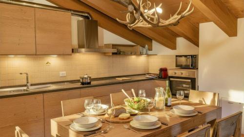 a kitchen with a table with plates and glasses at Chalet la Segheria in Temù
