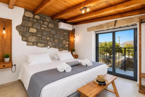 a bedroom with a large bed and a large window at La Casa Di Pietre 2 in Kiotari
